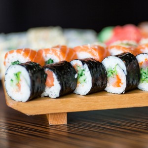 Sushi rolls served on a wooden plate
